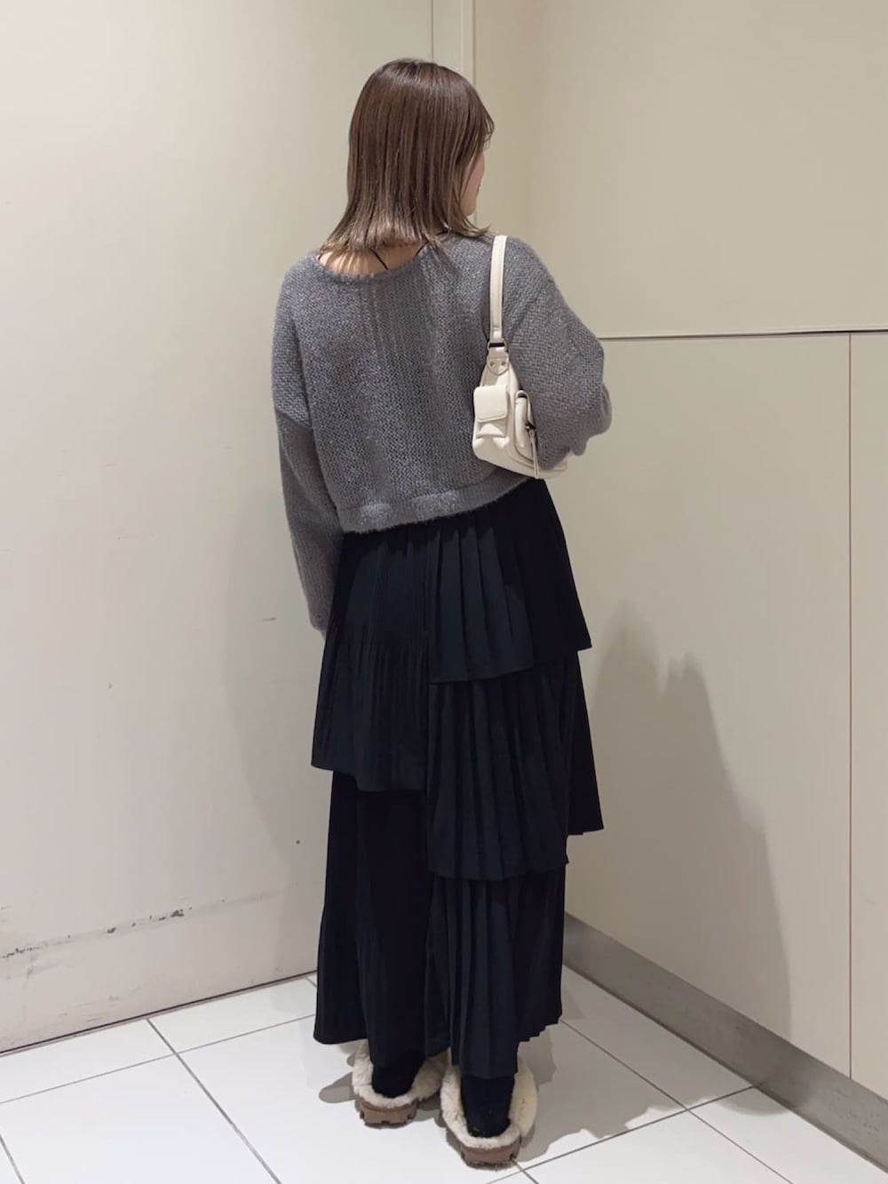 グレー系のニット/セーター、ブラック系のスカートを着用したレディースの冬コーディネートの2枚目の写真