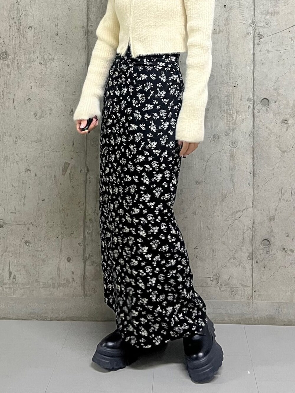 ホワイト系のニット/セーター、ブラック系のスカートを着用したレディースの冬コーディネートの3枚目の写真