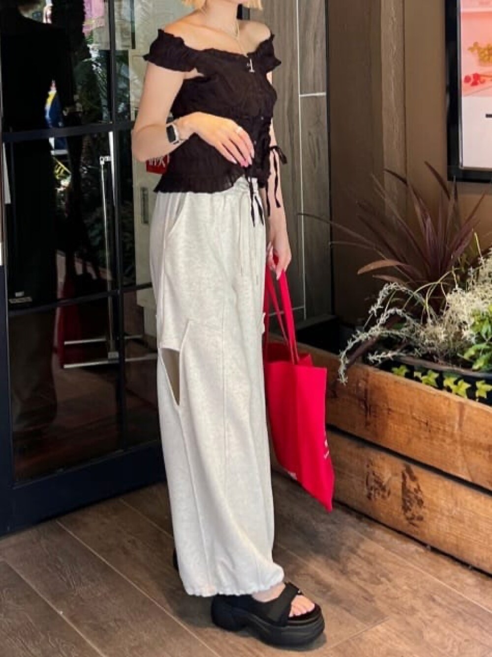 ブラック系のシャツ/ブラウス、グレー系のスウェットパンツ、ブラック系のサンダルを着用したレディースの夏コーディネートの2枚目の写真