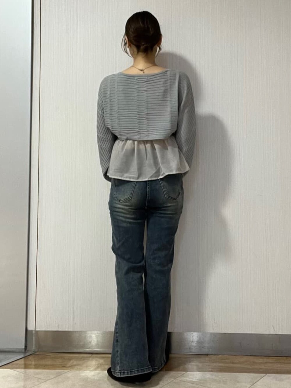 ブルー系のデニムパンツ、グレー系のアンサンブルを着用したレディースの秋コーディネートの3枚目の写真