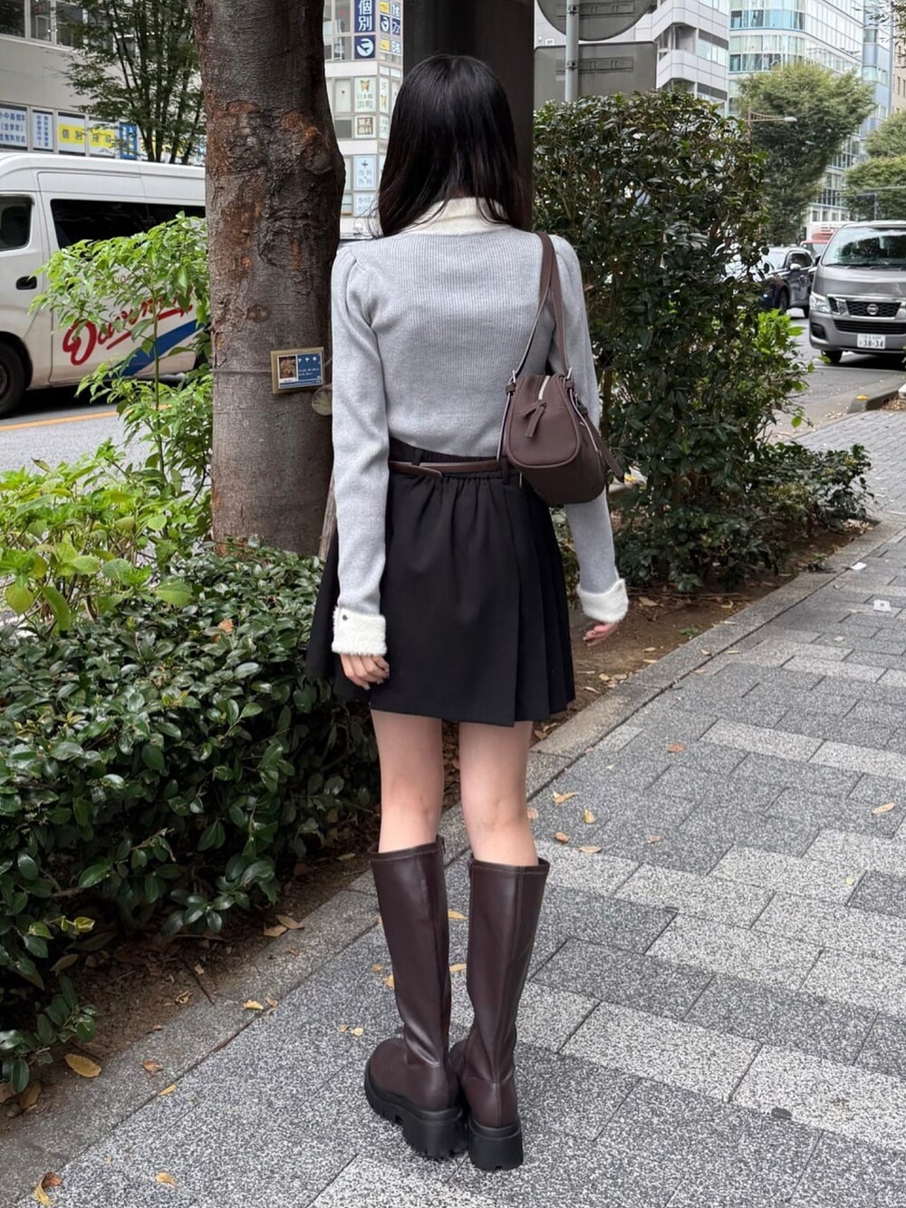 ブラック系のニット/セーター、ブラック系のスカート、ブラウン系のボストンバッグを着用したレディースの秋コーディネートの3枚目の写真