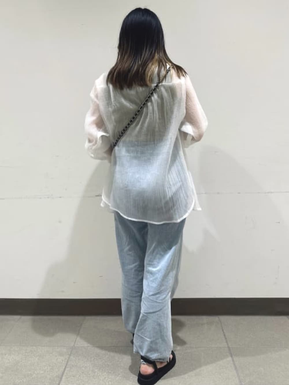 ブラック系のショルダーバッグ、ホワイト系のシャツ/ブラウス、ブルー系のデニムパンツを着用したレディースの夏コーディネートの2枚目の写真