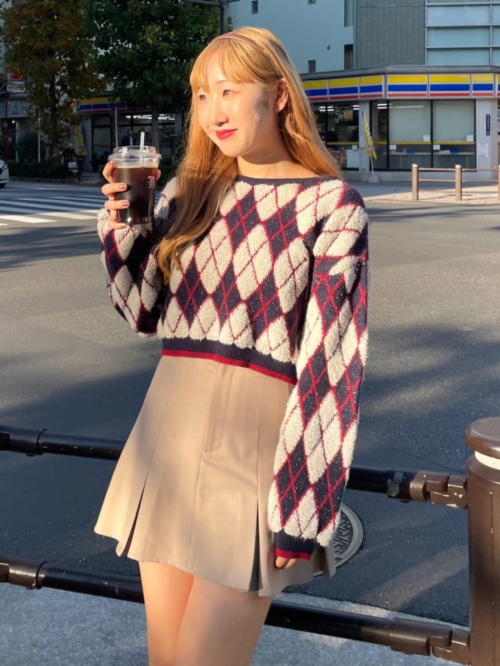 ブルー系のニット/セーター、ベージュ系のスカート、グレー系のローファーを着用したレディースの冬コーディネートの3枚目の写真