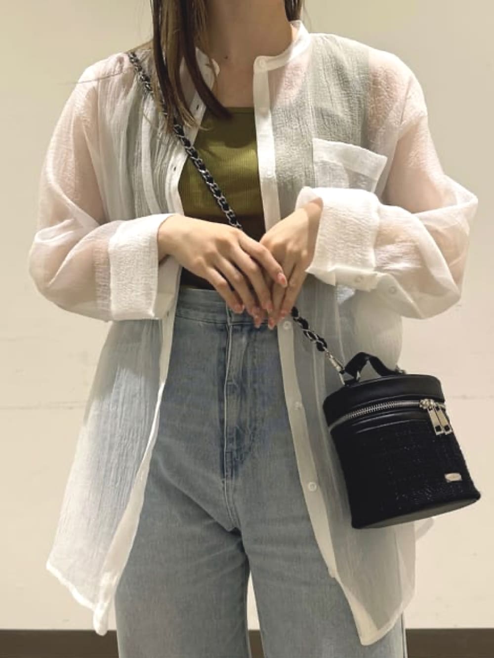 ブラック系のショルダーバッグ、ホワイト系のシャツ/ブラウス、ブルー系のデニムパンツを着用したレディースの夏コーディネートの3枚目の写真