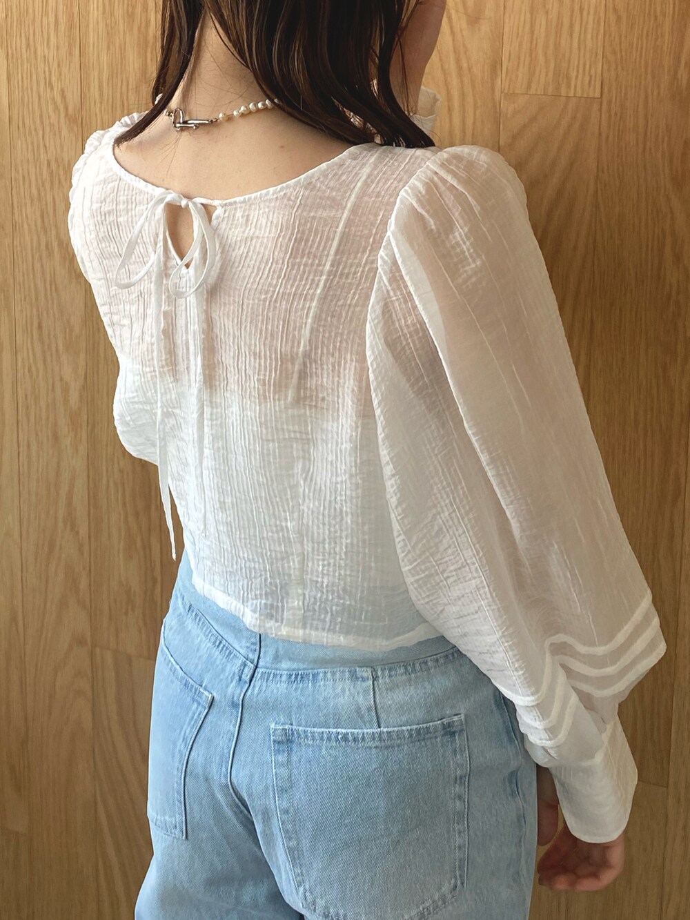 ホワイト系のシャツ/ブラウス、ブルー系のデニムパンツ、ホワイト系のサンダルを着用したレディースの春コーディネートの4枚目の写真