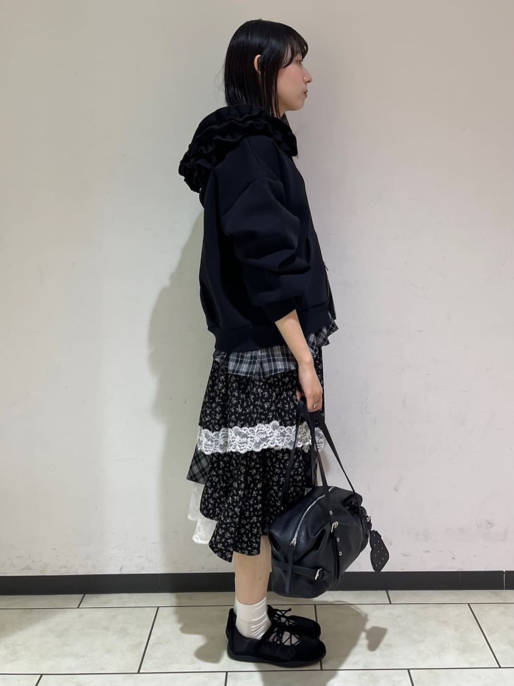 ブラック系のTシャツ/カットソー、ブラック系のスカート、ブラック系のボストンバッグを着用したレディースの秋コーディネートの2枚目の写真