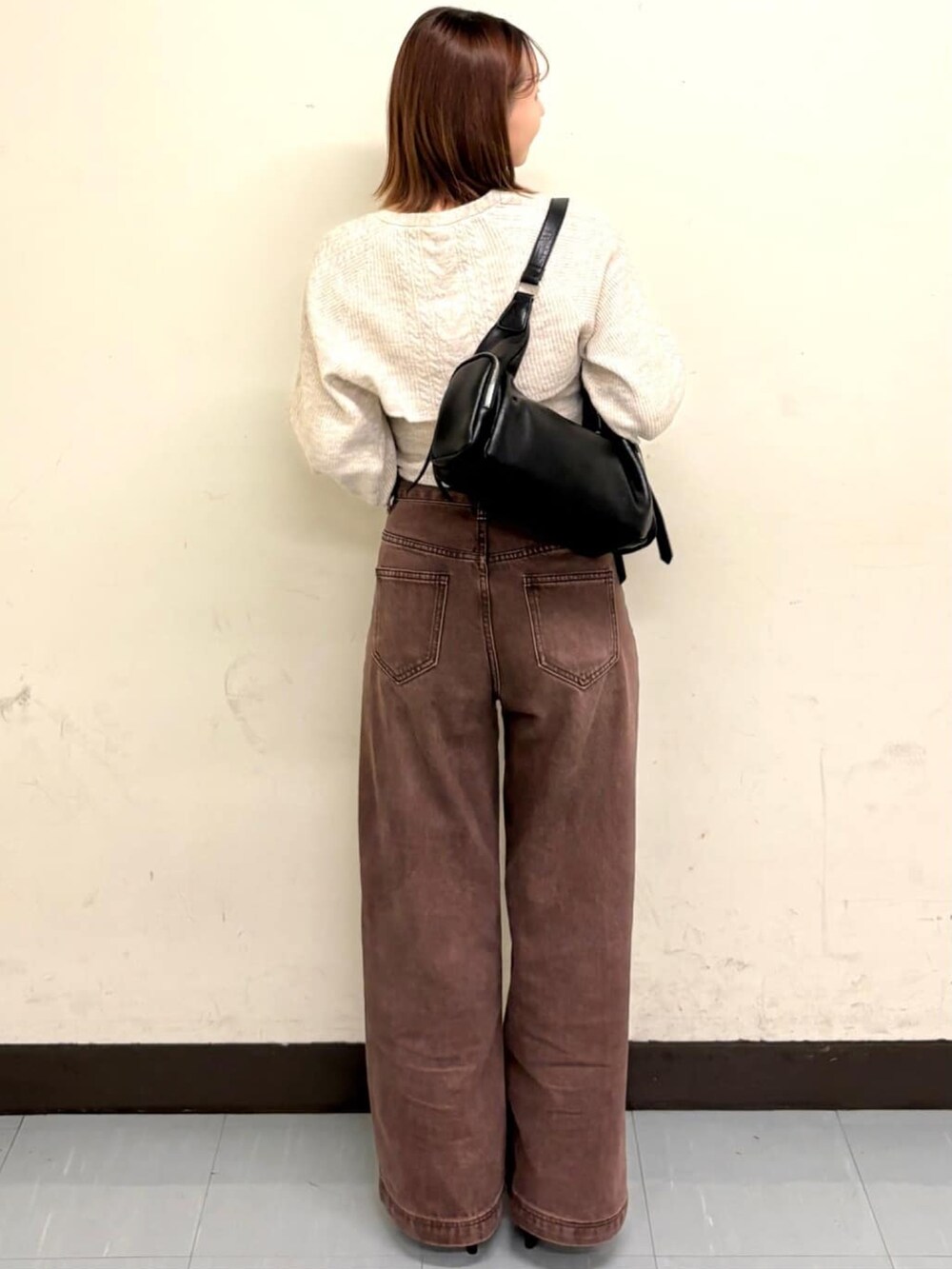 ホワイト系のアンサンブル、ブラウン系のデニムパンツを着用したレディースの秋コーディネートの3枚目の写真