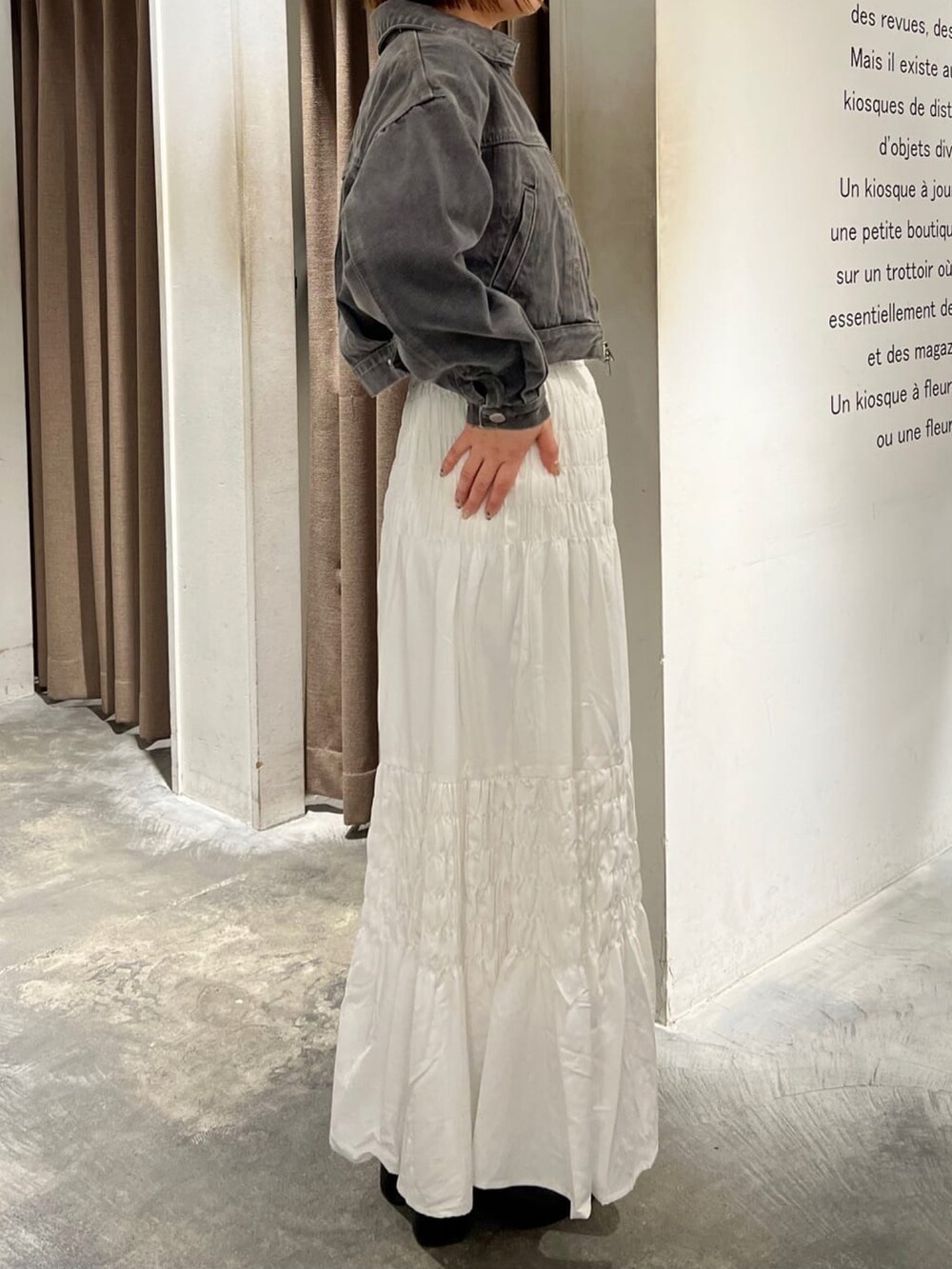 グレー系のブルゾン、ホワイト系のスカートを着用したレディースの春コーディネートの2枚目の写真