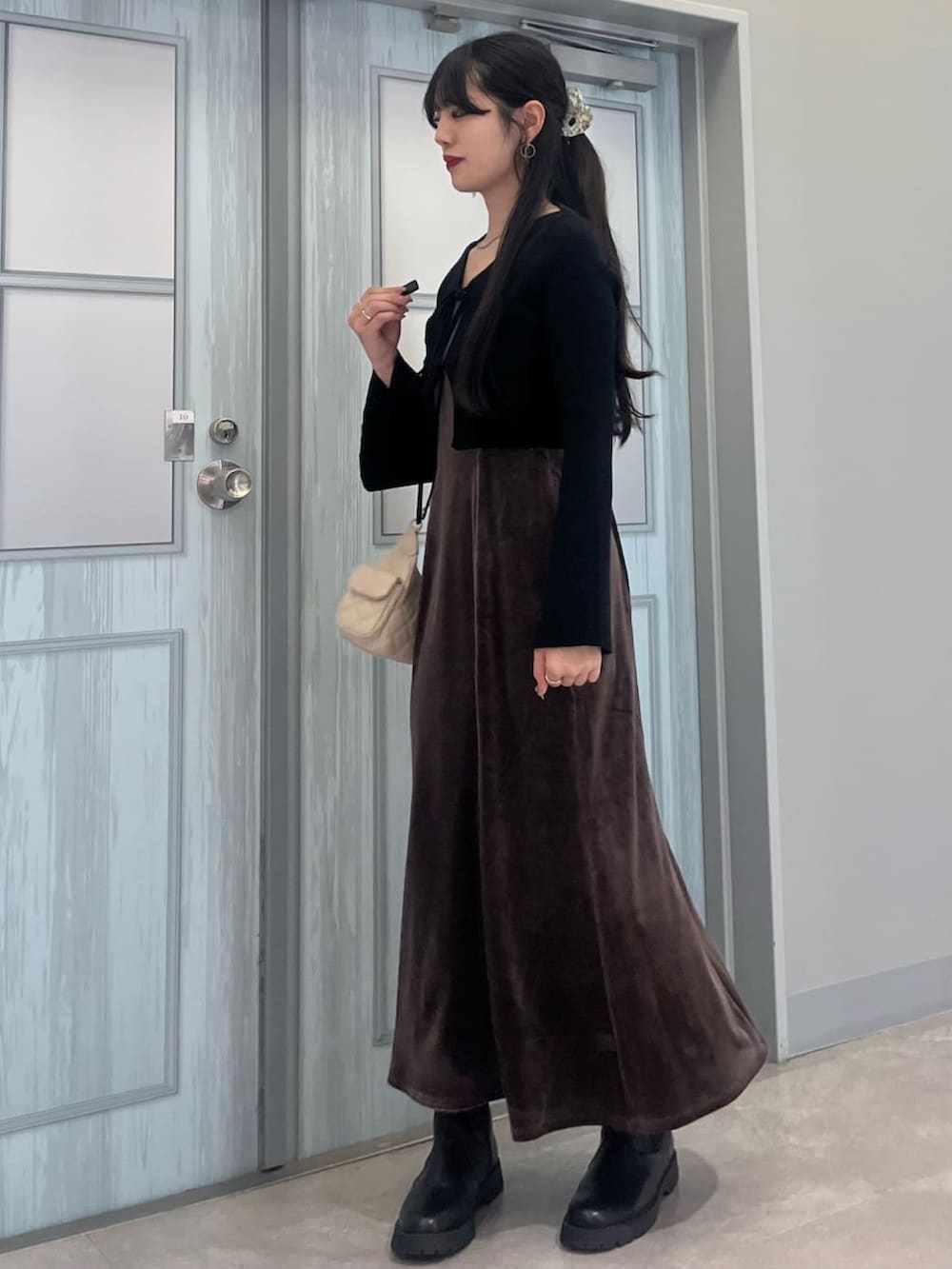 ブラウン系のワンピースを着用したレディースの冬コーディネートの2枚目の写真