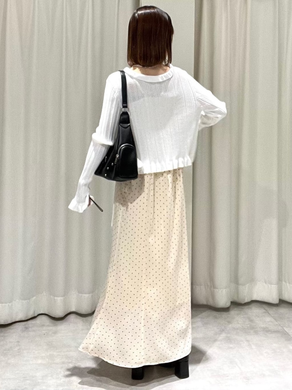 ホワイト系のカーディガン/ボレロ、ホワイト系のワンピースを着用したレディースの春コーディネートの2枚目の写真