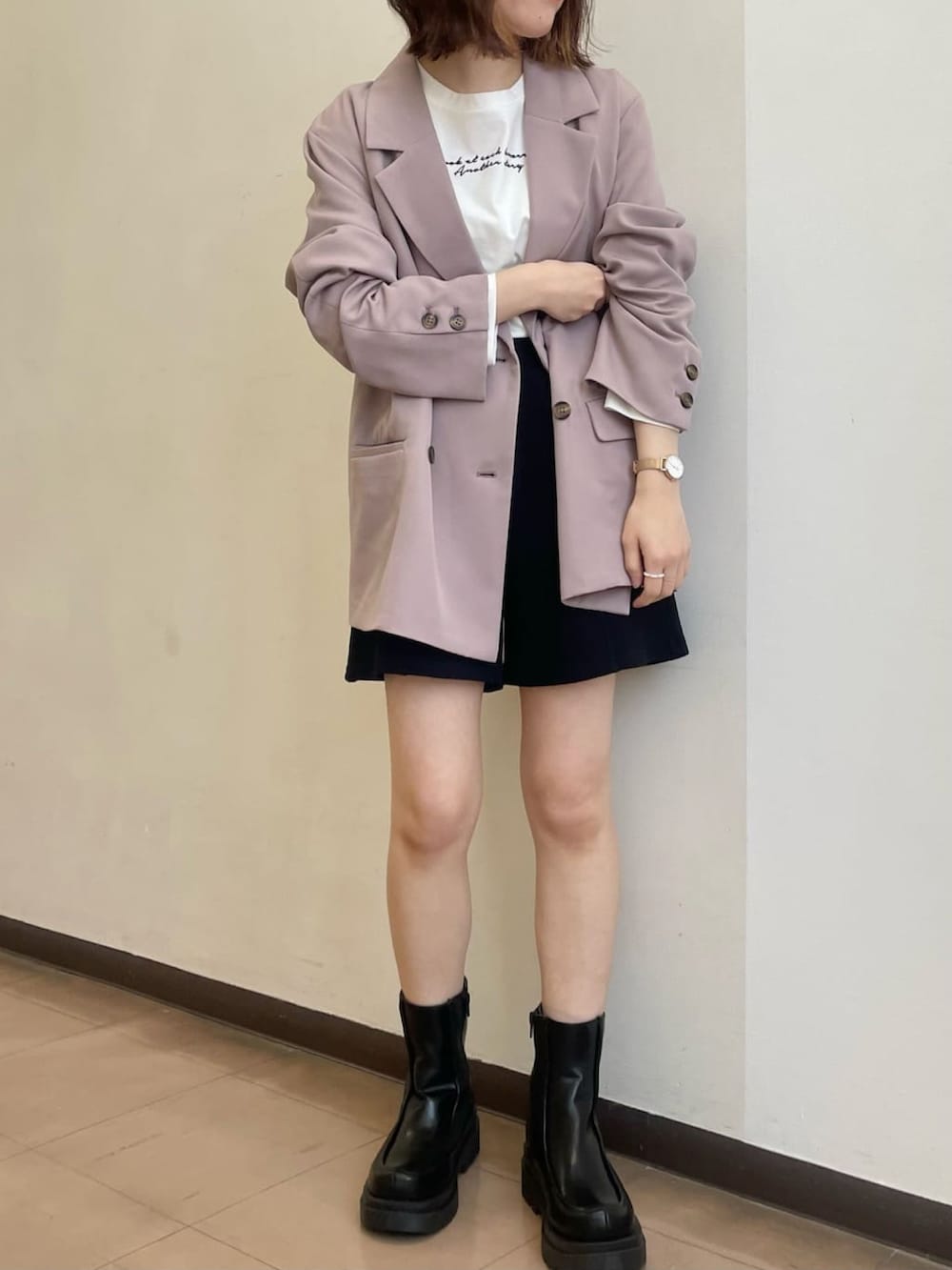 ピンク系のテーラードジャケット、ブラック系のブーツを着用したレディースの春コーディネートの2枚目の写真