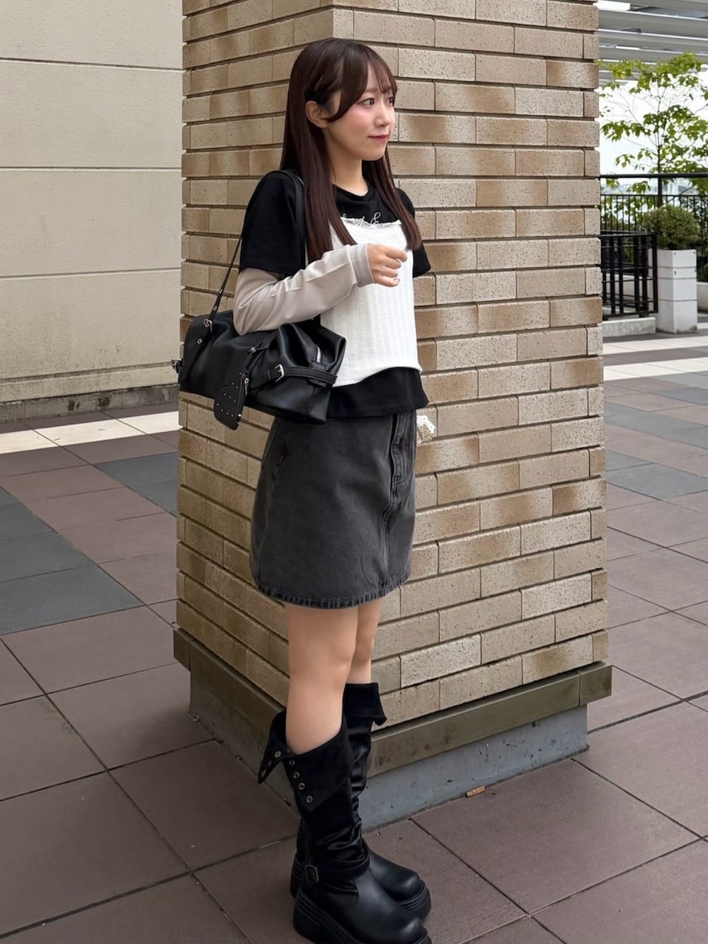 ホワイト系のTシャツ/カットソー、ブラック系のデニムスカート、ブラック系のボストンバッグを着用したレディースの秋コーディネートの2枚目の写真