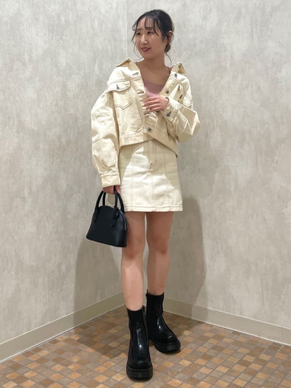 ホワイト系のデニムジャケット、ピンク系のTシャツ/カットソー、ホワイト系のデニムスカートを着用したレディースの春コーディネートの3枚目の写真