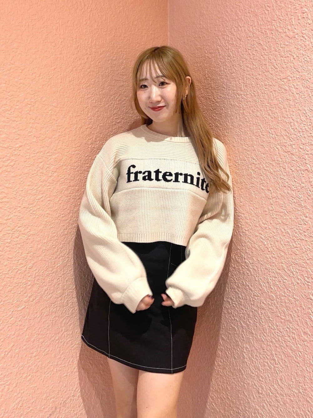 ホワイト系のニット/セーター、ブラック系のスカート、ブラウン系のブーツを着用したレディースの冬コーディネートの2枚目の写真