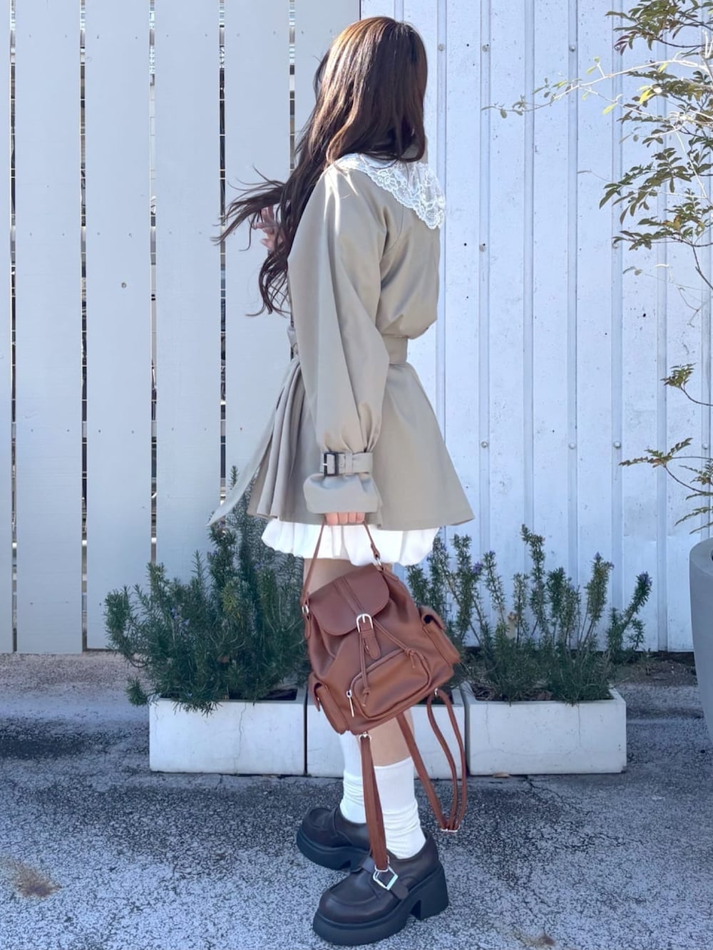 グリーン系のトレンチコートを着用したレディースの冬コーディネートの2枚目の写真