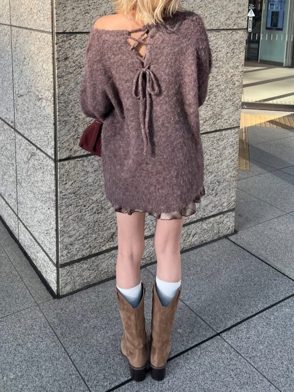 ブラウン系のニット/セーター、ブラウン系のスカート、ブラウン系のブーツを着用したレディースの秋コーディネートの3枚目の写真