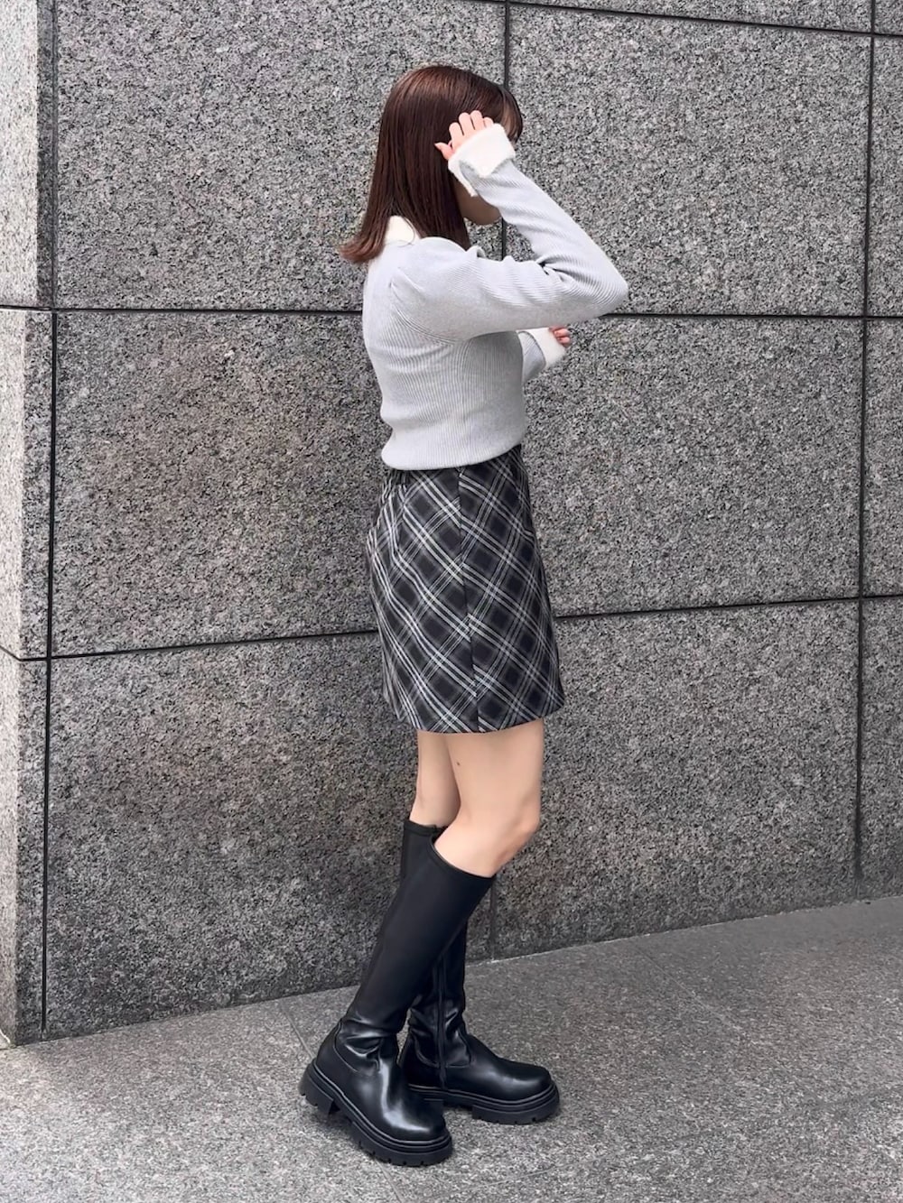 グレー系のニット/セーター、グレー系のスカートを着用したレディースの秋コーディネートの3枚目の写真