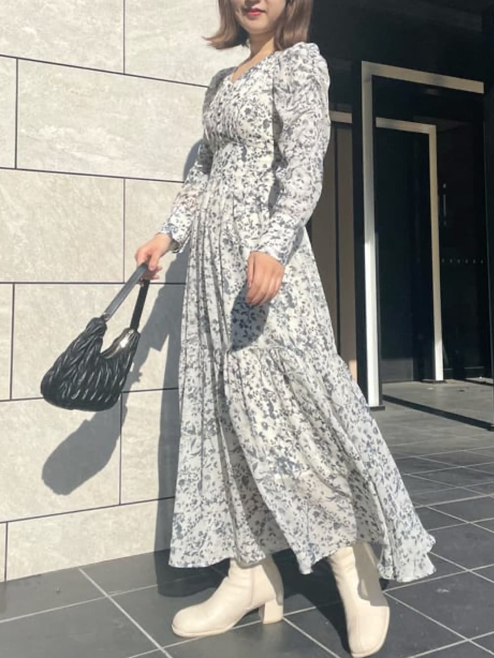 ホワイト系のワンピース、ブラック系のハンドバッグを着用したレディースの冬コーディネートの2枚目の写真