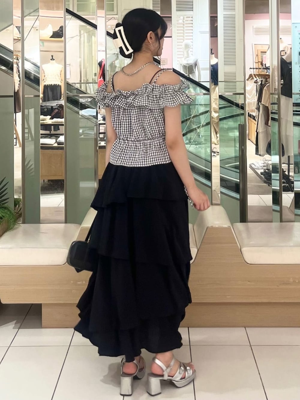 ブラック系のスカート、ブラック系のシャツ/ブラウスを着用したレディースの夏コーディネートの3枚目の写真