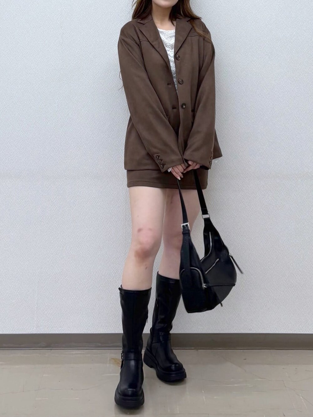 ブラウン系のテーラードジャケット、ブラウン系のスカートを着用したレディースの秋コーディネートの2枚目の写真
