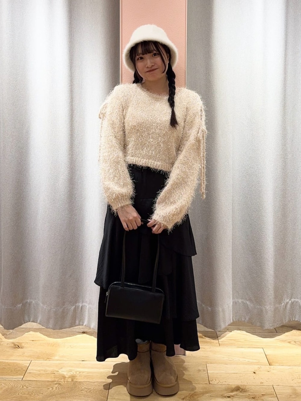ホワイト系のニット/セーター、ブラウン系のブルゾン、ブラック系のスカートを着用したレディースの冬コーディネートの3枚目の写真