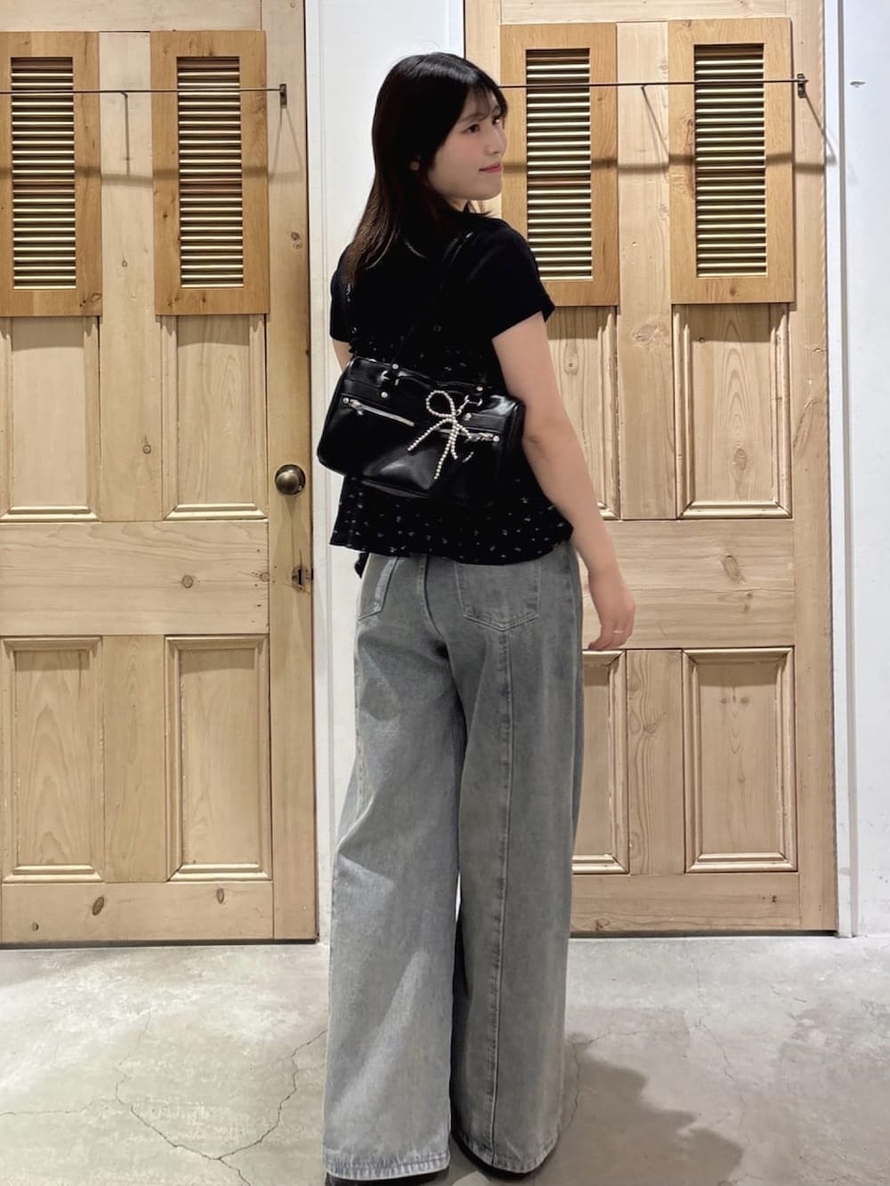 ブラック系のアンサンブル、ブルー系のデニムパンツを着用したレディースの夏コーディネートの2枚目の写真