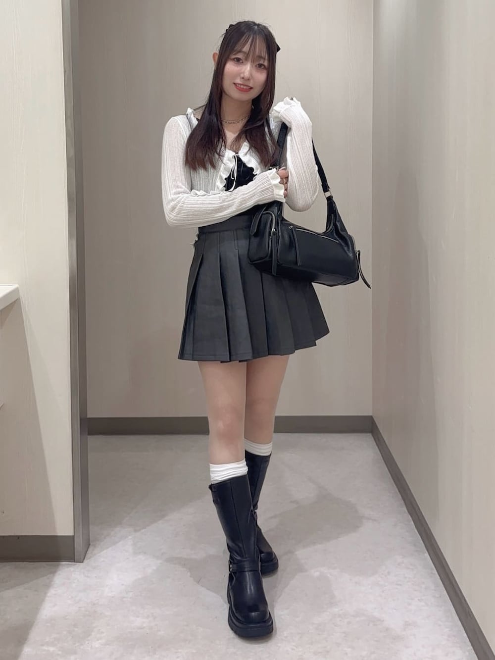 ブラック系のスカート、ホワイト系のカーディガン/ボレロを着用したレディースの夏コーディネートの2枚目の写真