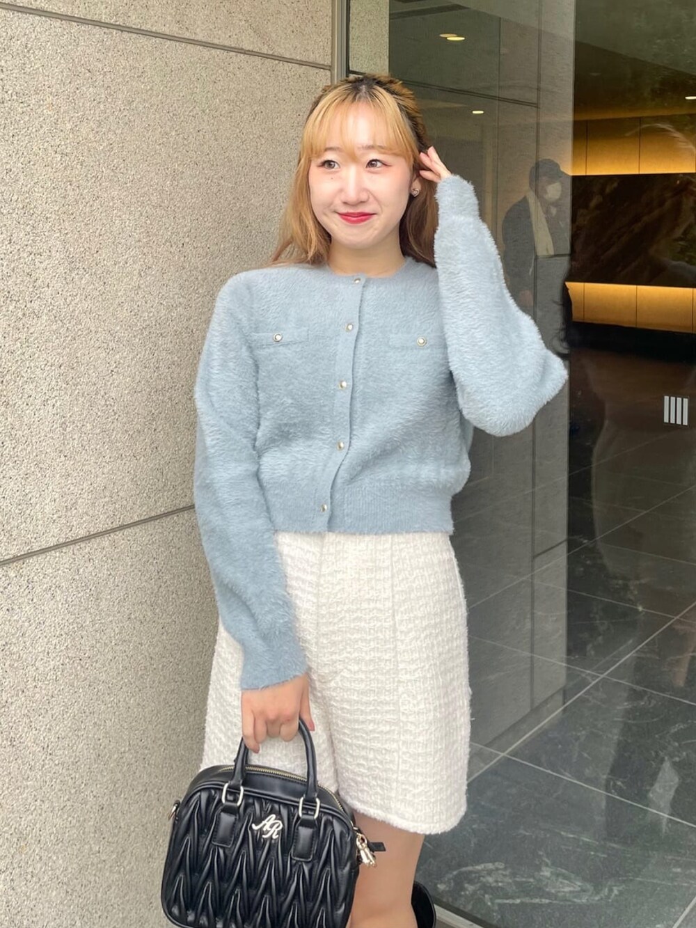 ブルー系のニット/セーター、ホワイト系のその他パンツ、ブラック系のブーツを着用したレディースの冬コーディネートの2枚目の写真