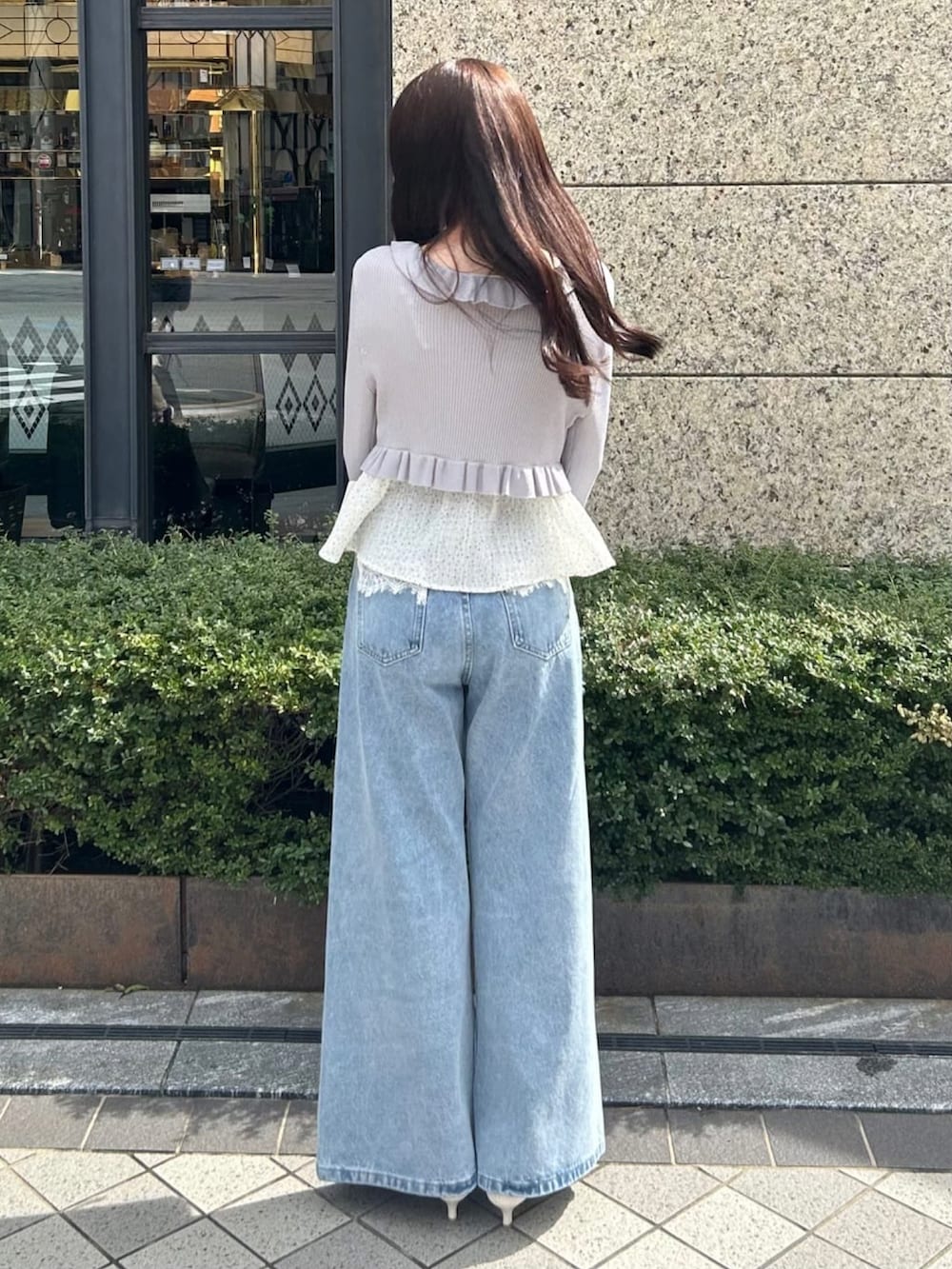 グレー系のアンサンブル、ブルー系のデニムパンツを着用したレディースの春コーディネートの3枚目の写真