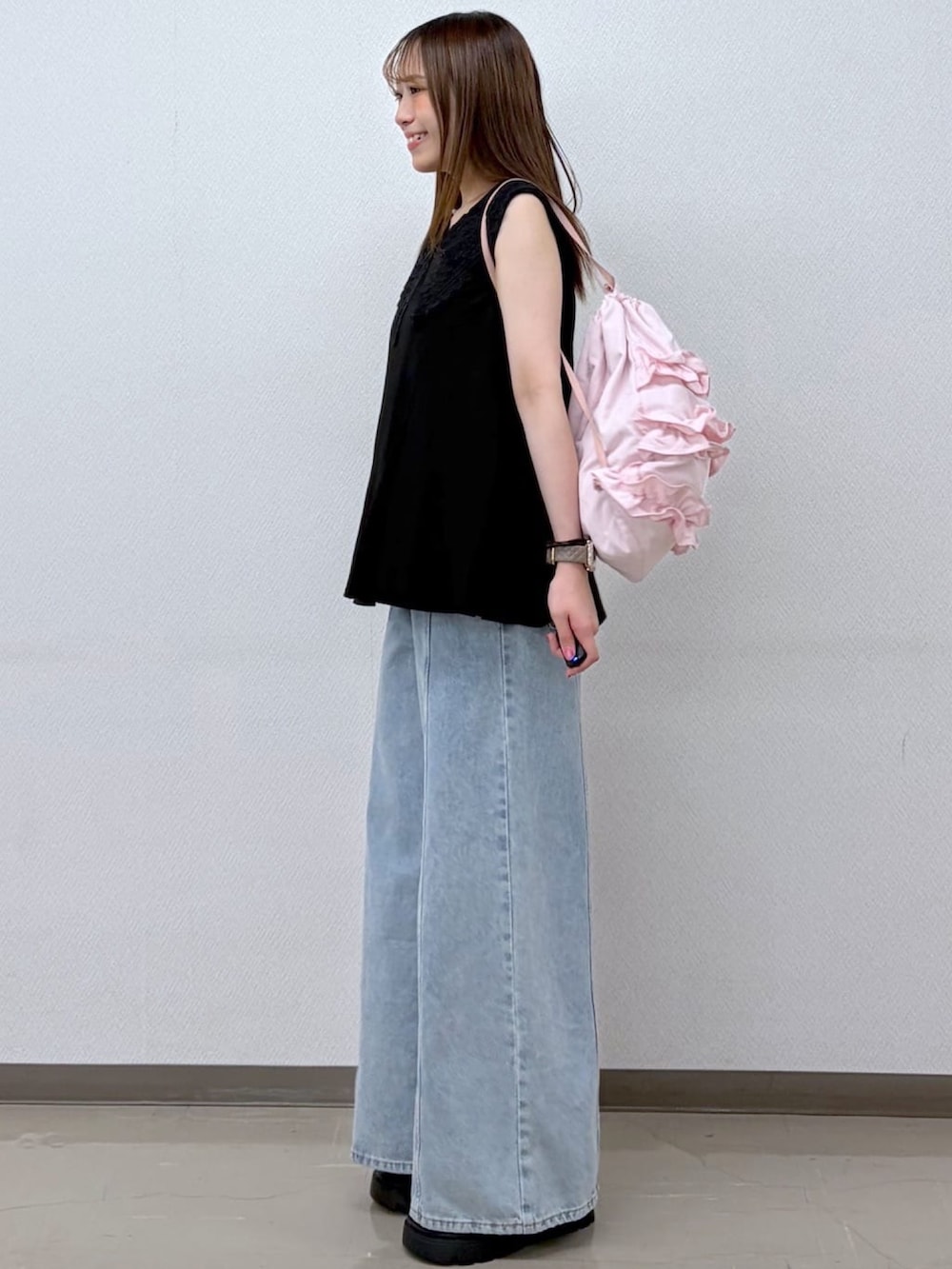 ブルー系のデニムパンツ、ブラック系のシャツ/ブラウス、ピンク系のショルダーバッグを着用したレディースの夏コーディネートの2枚目の写真