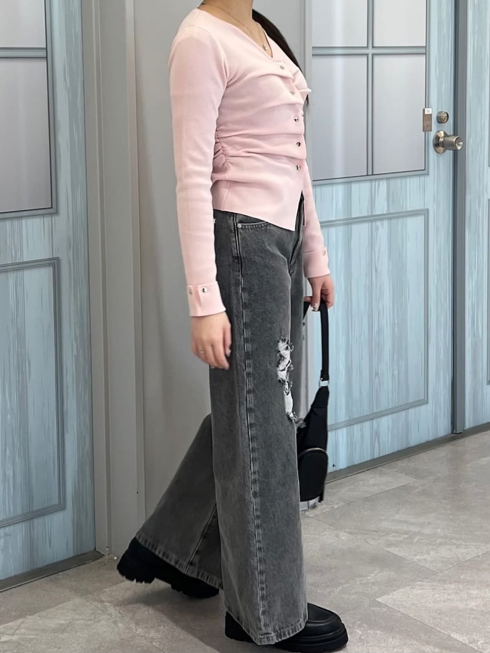 ピンク系のニット/セーター、グレー系のデニムパンツを着用したレディースの冬コーディネートの2枚目の写真