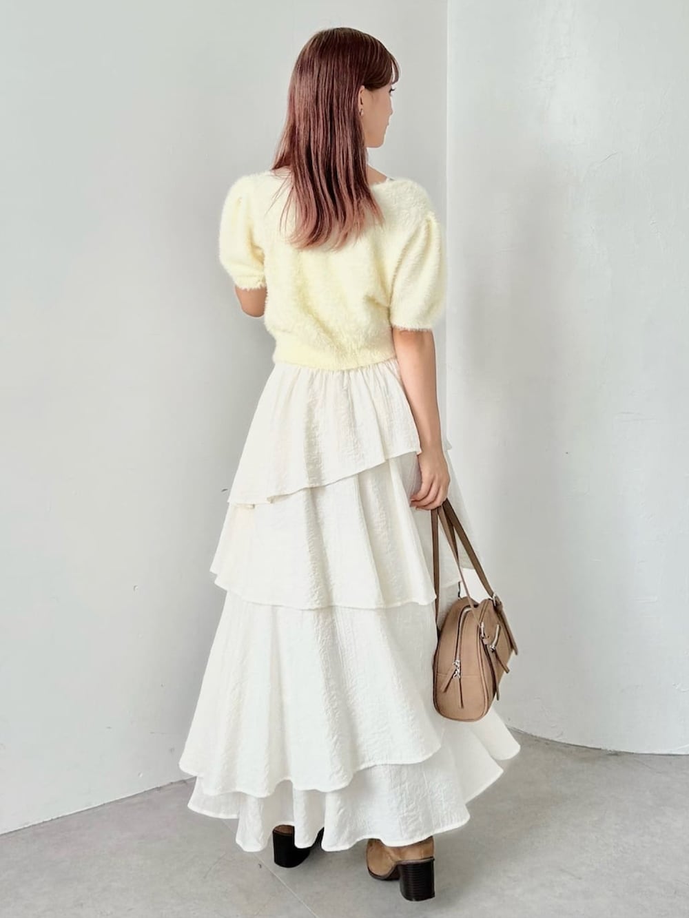 グリーン系のカーディガン/ボレロ、ホワイト系のスカートを着用したレディースの秋コーディネートの3枚目の写真