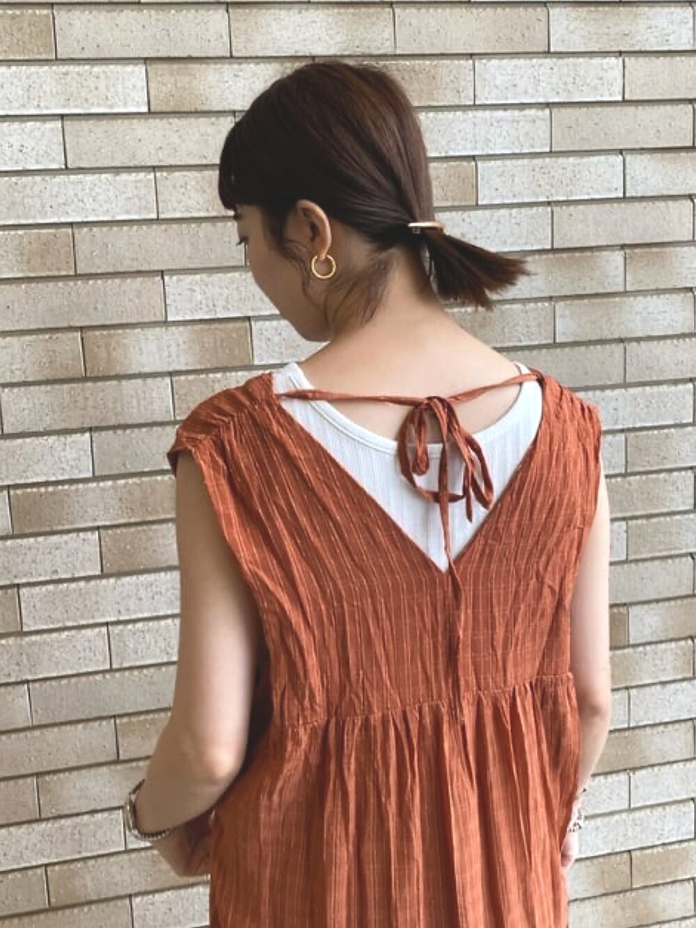 レッド系のワンピース、ブラック系のサンダルを着用したレディースの夏コーディネートの2枚目の写真