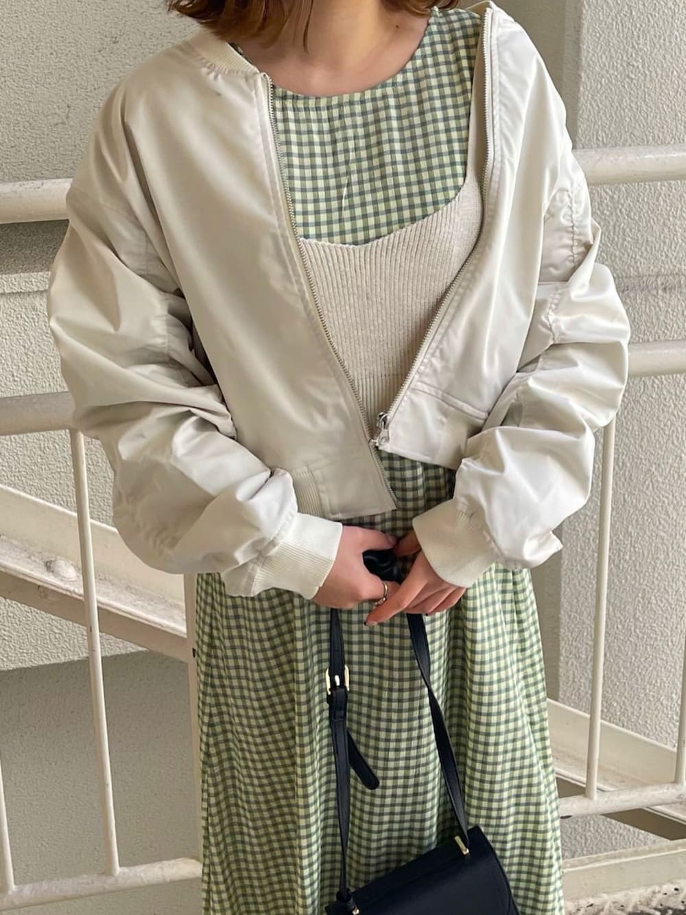 ホワイト系のMA-1、グリーン系のワンピース、ブラック系のローファーを着用したレディースの春コーディネートの2枚目の写真