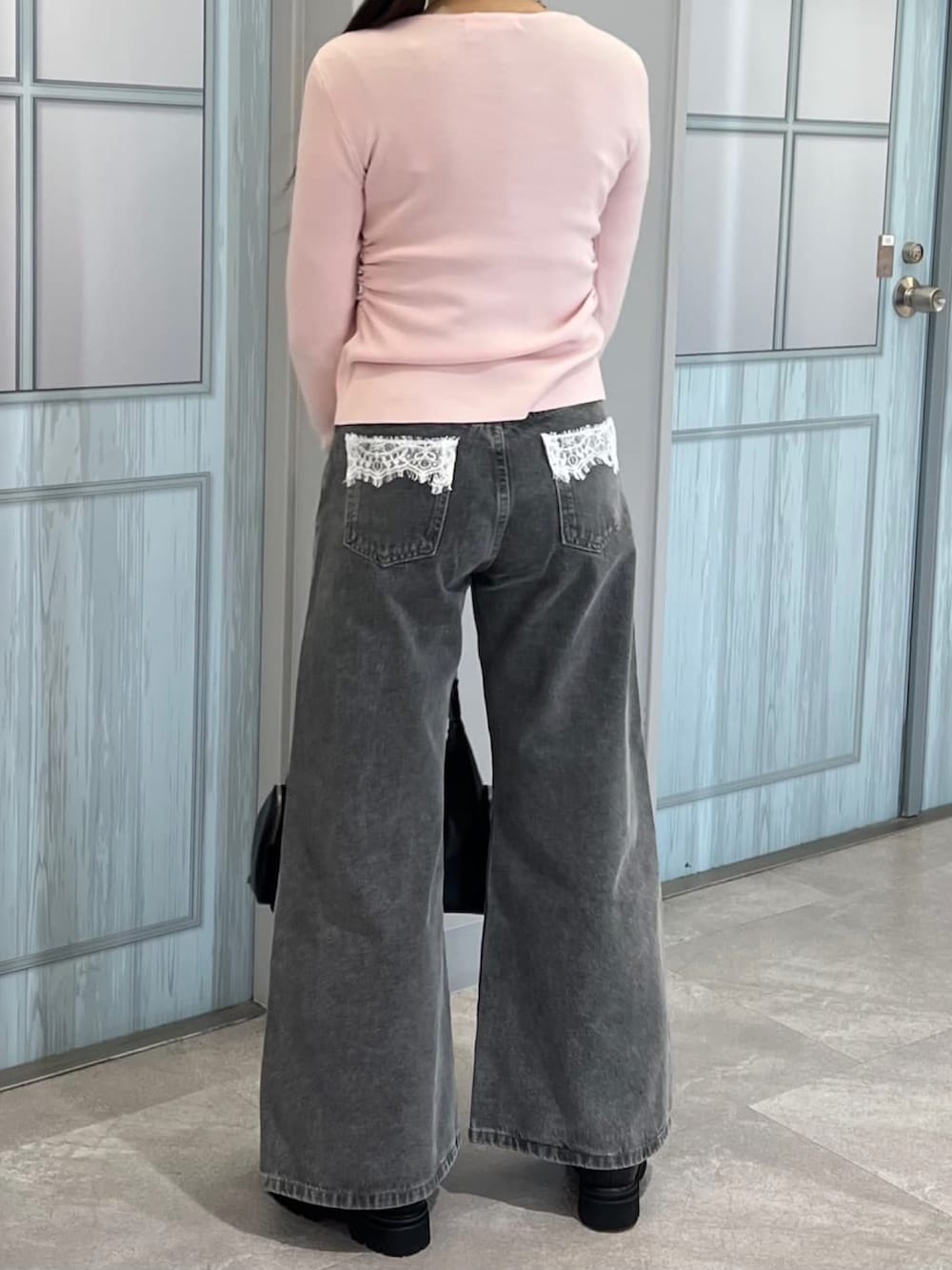 ピンク系のニット/セーター、グレー系のデニムパンツを着用したレディースの冬コーディネートの3枚目の写真