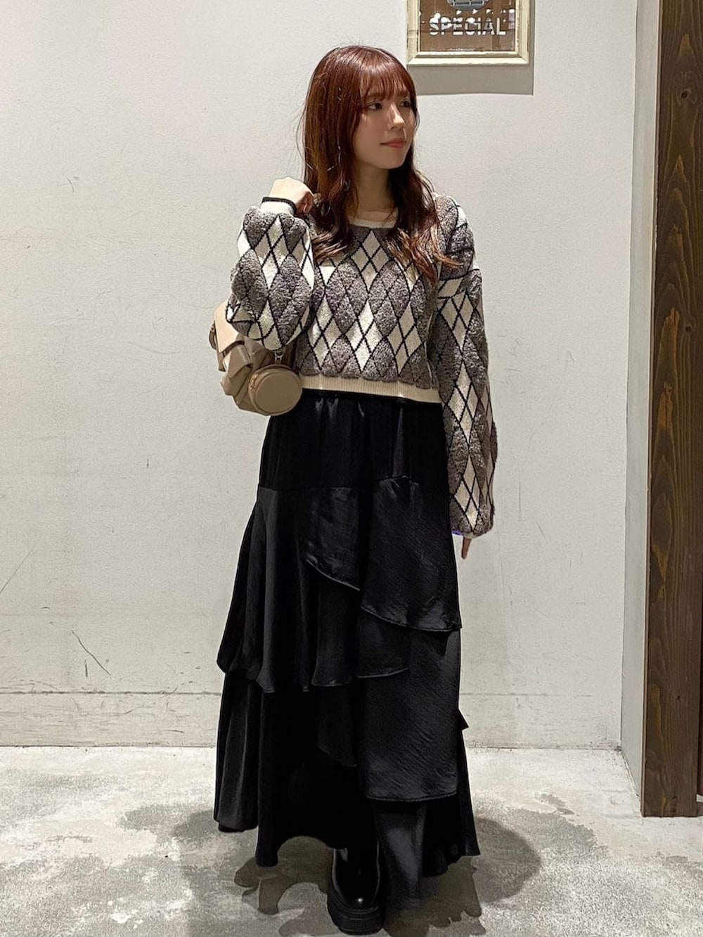 グレー系のニット/セーター、ブラック系のスカート、ホワイト系のダウンジャケット/コートを着用したレディースの冬コーディネートの3枚目の写真