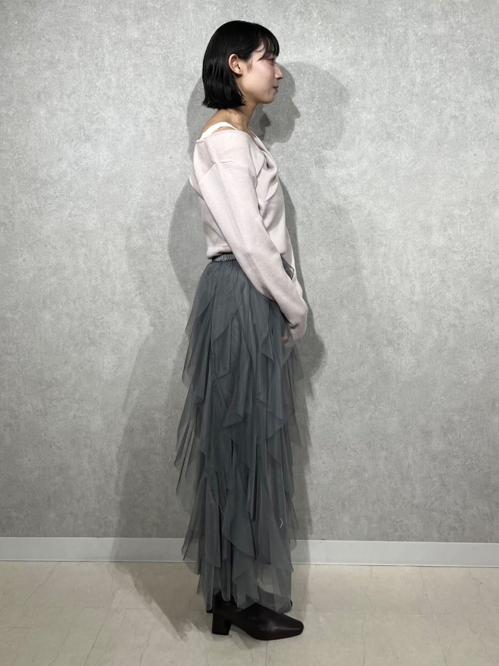 ピンク系のニット/セーター、グレー系のスカートを着用したレディースの冬コーディネートの2枚目の写真