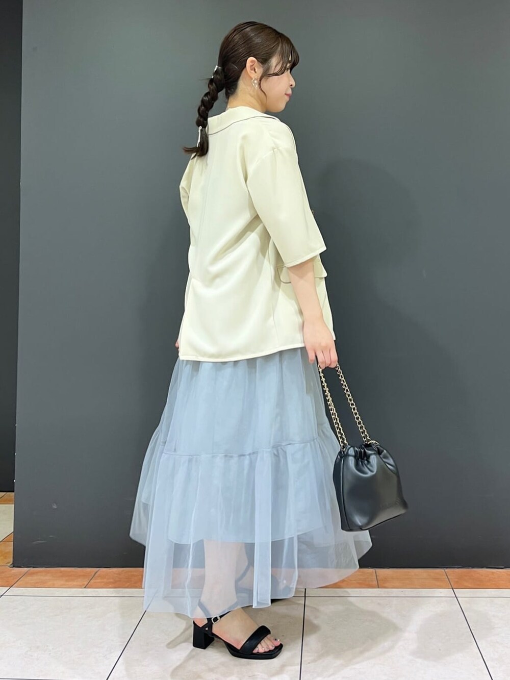 ホワイト系のテーラードジャケット、グレー系のワンピース、ホワイト系のサンダルを着用したレディースの夏コーディネートの3枚目の写真