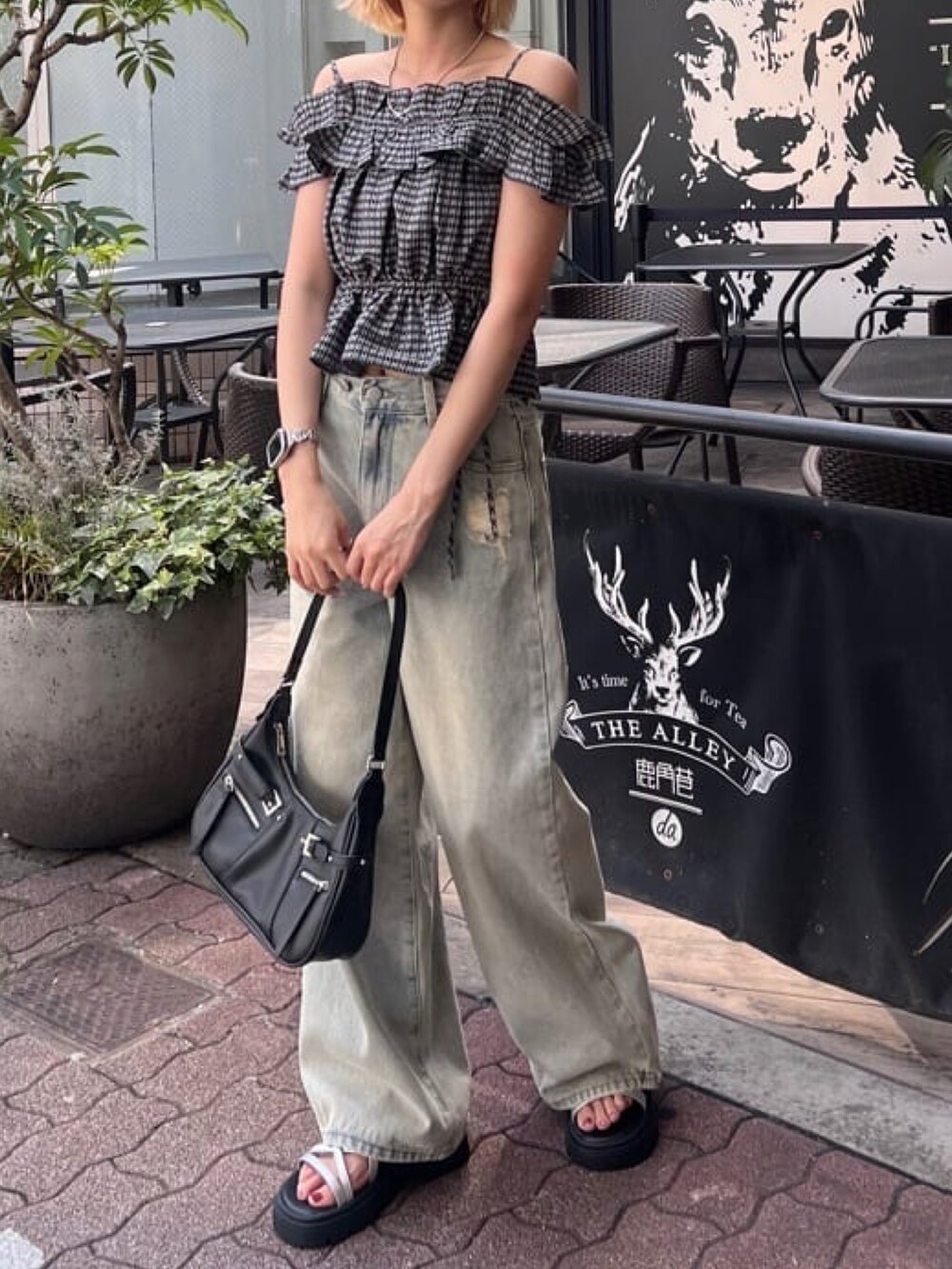 ブラック系のシャツ/ブラウス、ブルー系のデニムパンツを着用したレディースの夏コーディネートの2枚目の写真