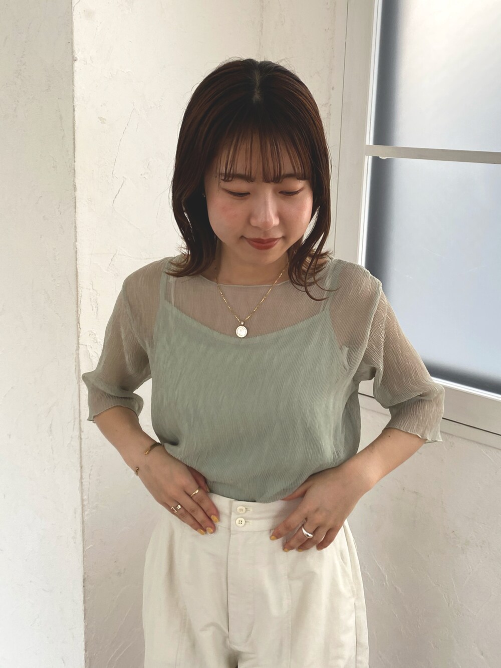 ホワイト系のカーゴパンツ、ホワイト系のサンダルを着用したレディースの春コーディネートの2枚目の写真