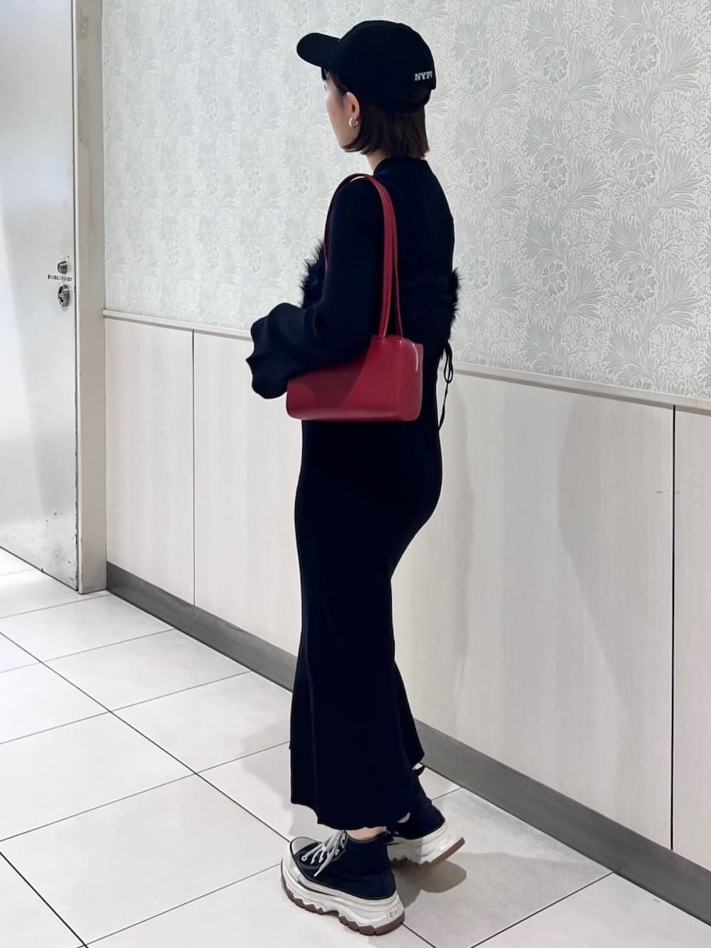 ブラック系のワンピース、レッド系のショルダーバッグを着用したレディースの冬コーディネートの3枚目の写真