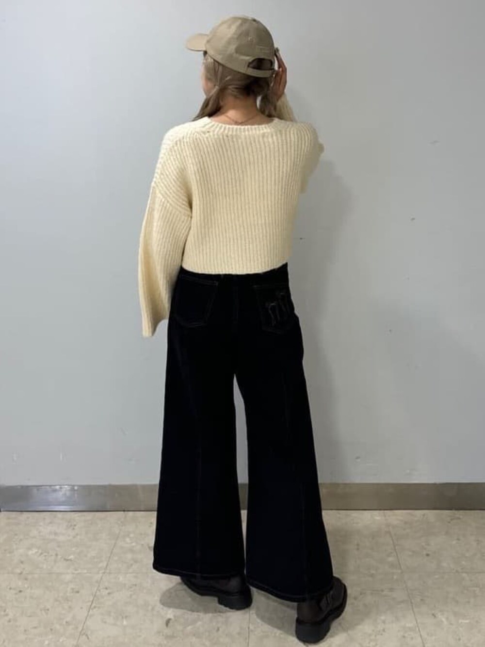 ホワイト系のニット/セーター、ブラック系のデニムパンツを着用したレディースの冬コーディネートの2枚目の写真