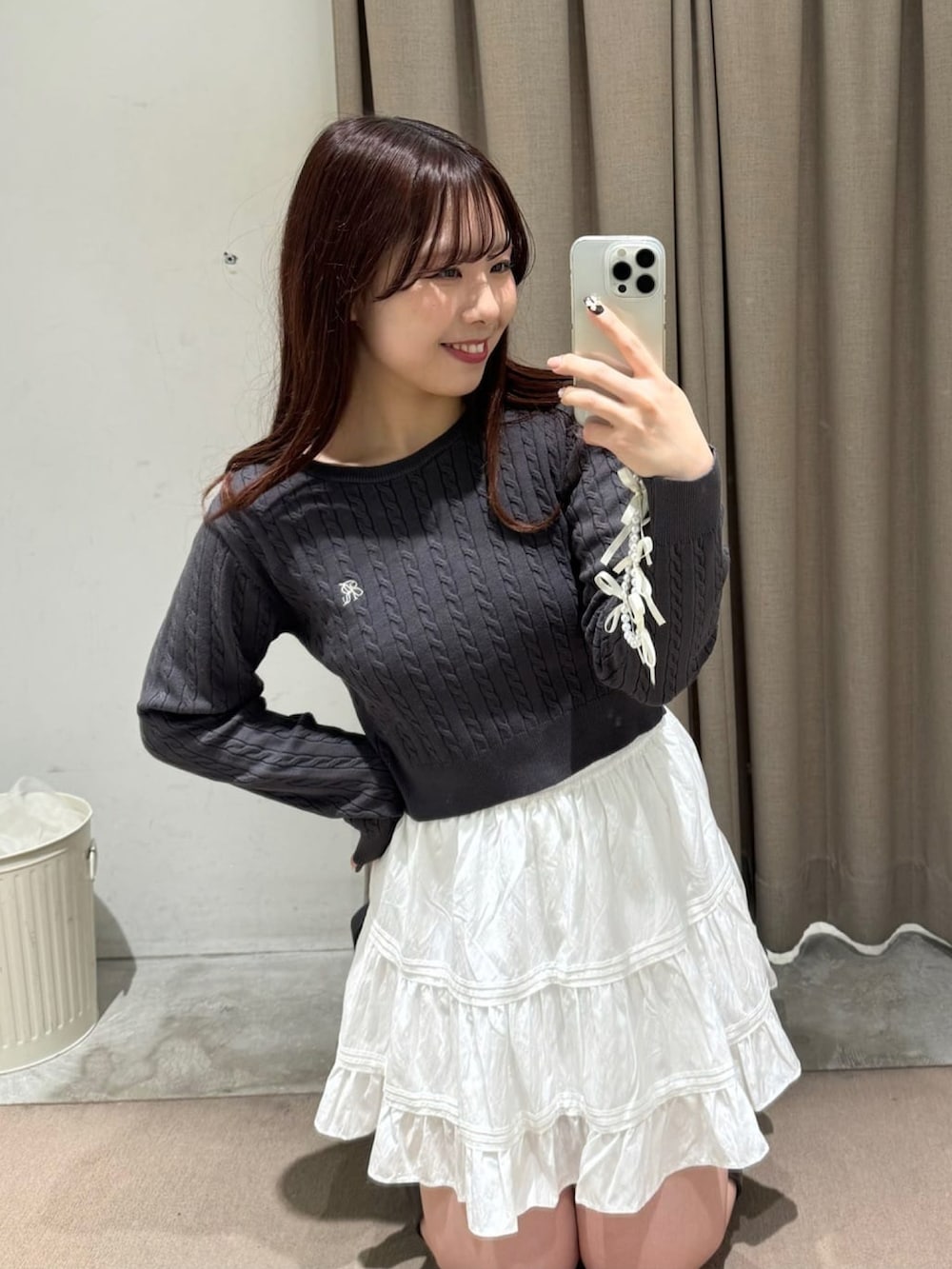 グレー系のニット/セーター、ホワイト系のブルゾン、ホワイト系のスカートを着用したレディースの冬コーディネートの3枚目の写真