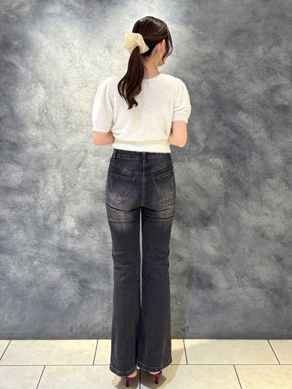 ホワイト系のカーディガン/ボレロ、グレー系のデニムパンツ、レッド系のパンプスを着用したレディースの秋コーディネートの3枚目の写真