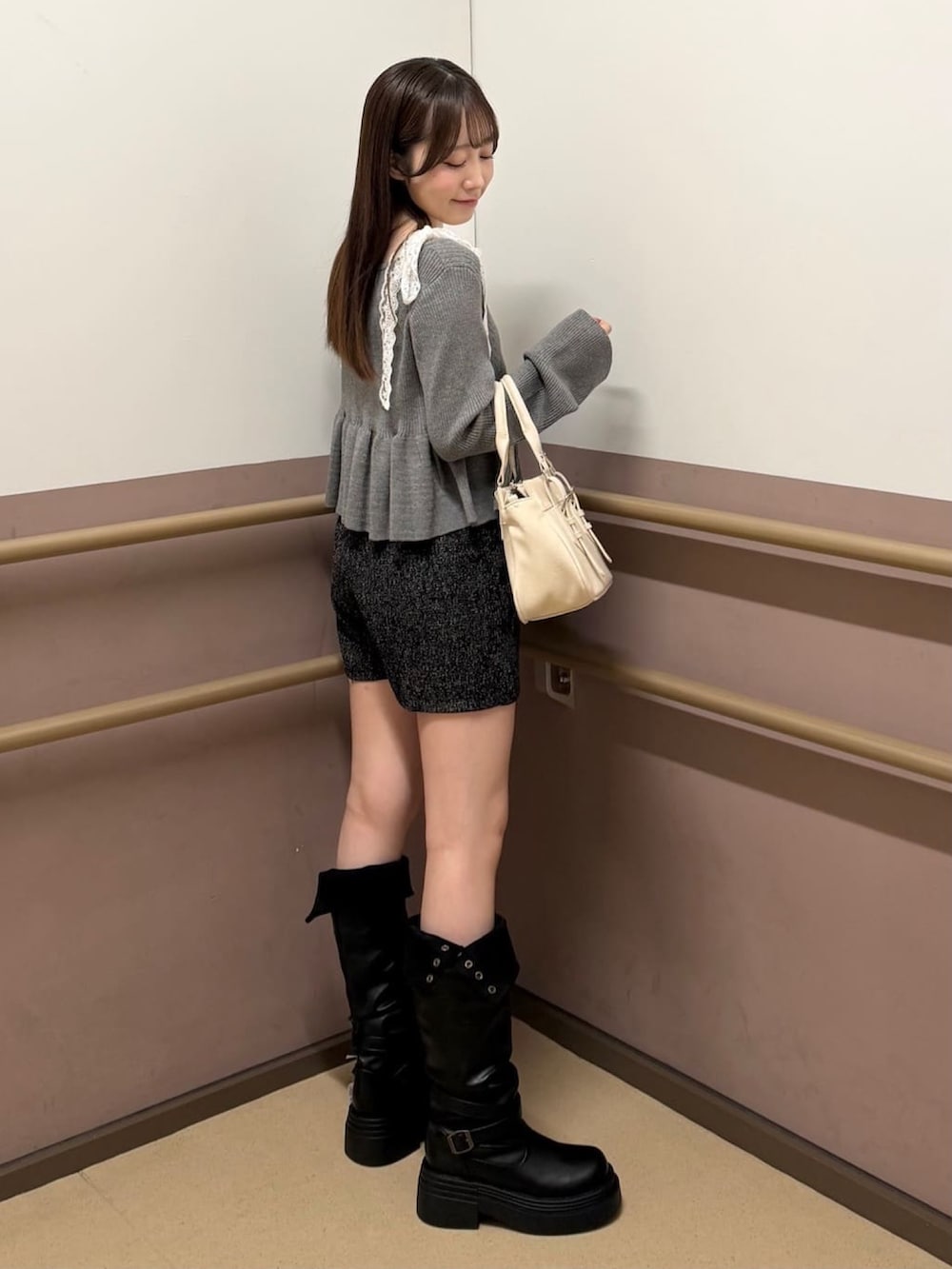 グレー系のアンサンブル、ホワイト系のショルダーバッグ、ブラック系のその他パンツを着用したレディースの秋コーディネートの2枚目の写真