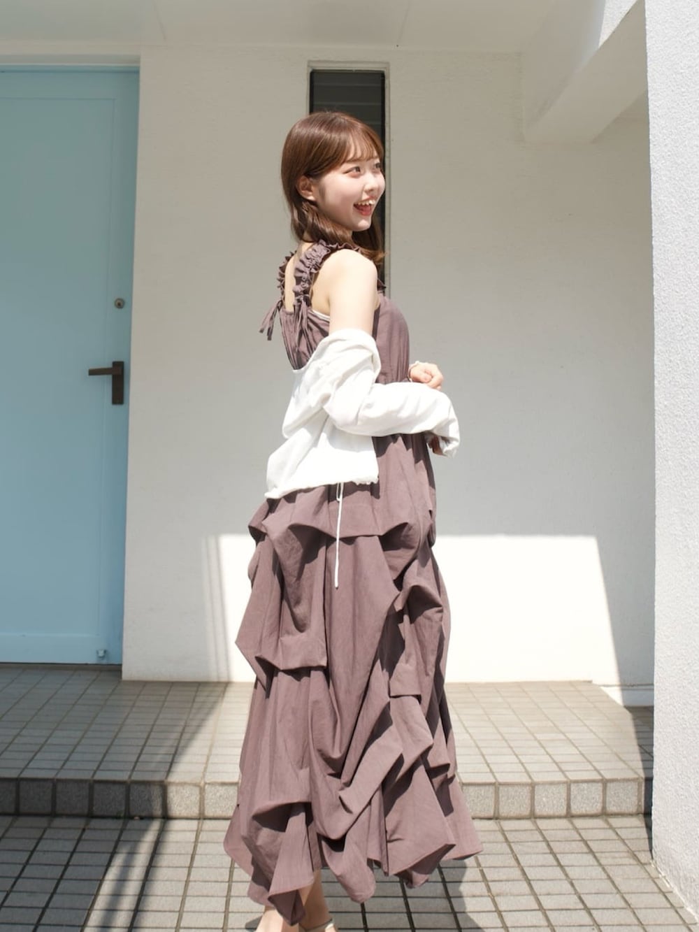 ブラウン系のワンピース、ホワイト系のニット/セーター、ホワイト系のサンダルを着用したレディースの夏コーディネートの2枚目の写真