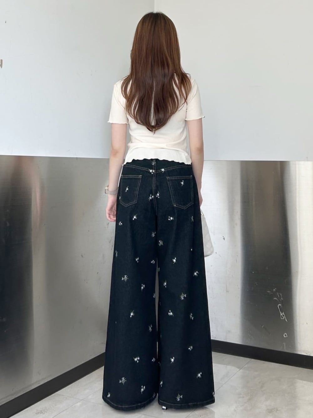 イエロー系のTシャツ/カットソー、ブラック系のデニムパンツを着用したレディースの夏コーディネートの2枚目の写真