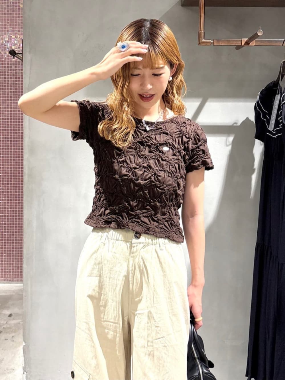 ブラック系のボストンバッグ、グレー系のサンダル、ブラウン系のTシャツ/カットソーを着用したレディースの夏コーディネートの4枚目の写真