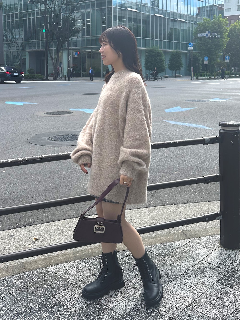 ピンク系のニット/セーター、ブラック系のブーツ、レッド系のハンドバッグを着用したレディースの秋コーディネートの2枚目の写真