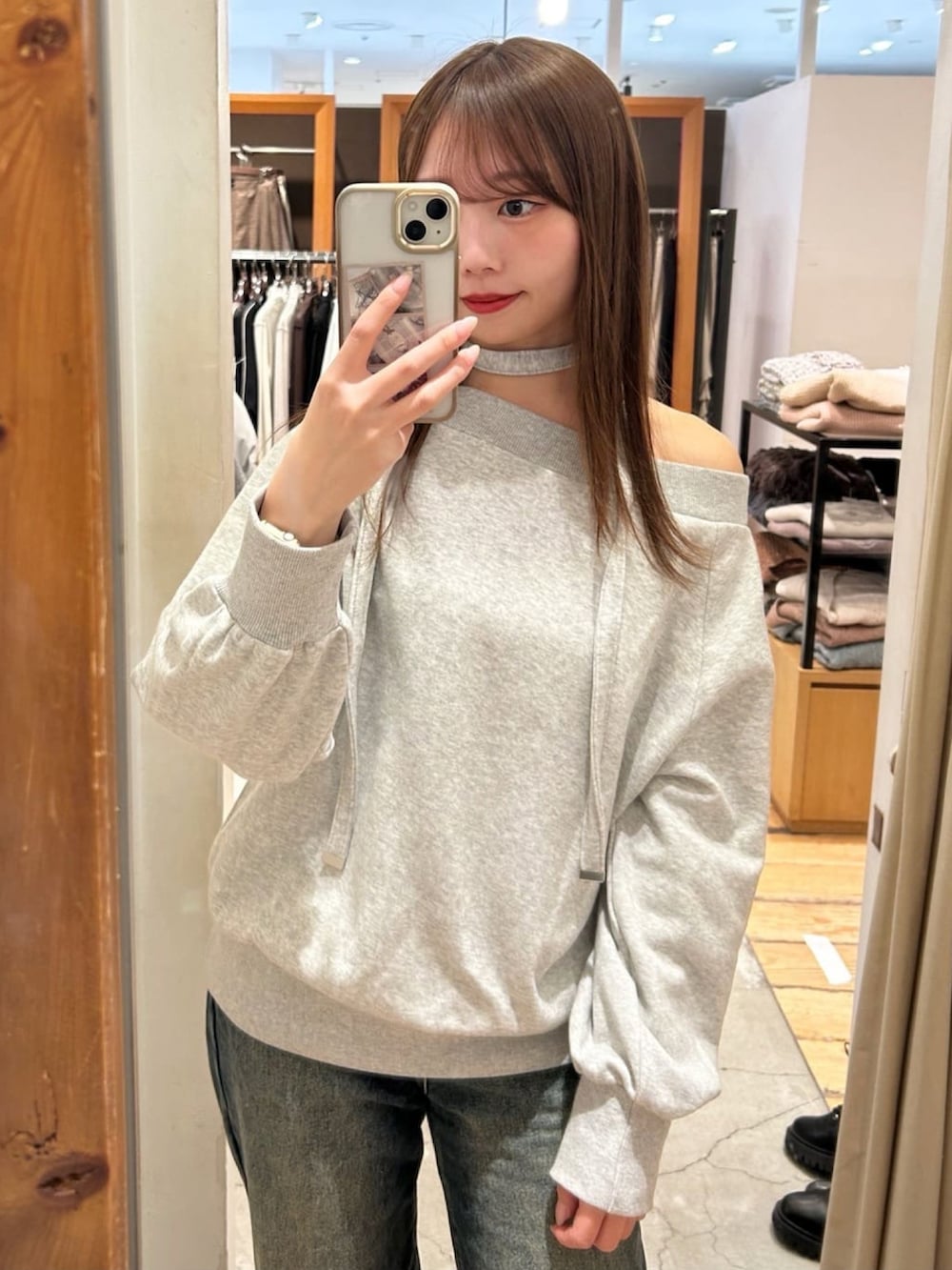 ブルー系のデニムパンツ、グレー系のスウェット、イエロー系のショルダーバッグを着用したレディースの冬コーディネートの3枚目の写真